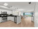 Modern kitchen featuring stainless steel appliances, granite countertops, and opens to the living area at 2 Oceans West Blvd # 702, Daytona Beach, FL 32118