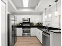 Well-appointed kitchen featuring stainless steel appliances, granite countertops, and modern lighting at 2 Oceans West Blvd # 702, Daytona Beach, FL 32118