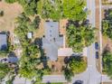 Aerial view of a landscaped property with a home, driveway, shed, and surrounding trees at 200 W Washington Ave, Deland, FL 32720