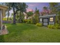 Well-maintained backyard with a storage shed, green lawn, and privacy fence, perfect for outdoor activities at 200 W Washington Ave, Deland, FL 32720