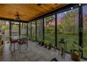 Enclosed sunroom with a ceiling fan, tile flooring, and views of the backyard and trees at 200 W Washington Ave, Deland, FL 32720