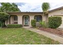 Inviting entryway with arched facade, a welcoming bench, and a walkway leading to the front door at 210 Delespine Dr, Debary, FL 32713