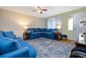 Comfortable living room featuring cozy blue sofas, a ceiling fan, and large area rug at 210 Delespine Dr, Debary, FL 32713