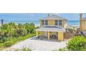 Beautiful yellow beach house with direct ocean access and spacious driveway at 2101 Hill St, New Smyrna Beach, FL 32169