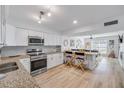 Charming kitchen features white cabinets, stainless steel appliances, granite countertops, and breakfast bar at 2122 S Atlantic Ave # 2122, New Smyrna Beach, FL 32169
