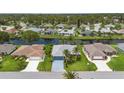 A lovely aerial view of a beautiful single Gathering home with well-manicured lawn and waterway in backyard at 223 Ne Golf Club Dr, New Smyrna Beach, FL 32168