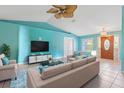 Bright living room with neutral-colored furniture, fan, and light fixture at 223 Ne Golf Club Dr, New Smyrna Beach, FL 32168