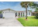 Charming single-Gathering home boasting a well-maintained front lawn and stucco exterior, accented by a central palm tree at 25 Dolphin Ave, Ormond Beach, FL 32176
