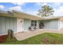 Charming single-story home features a well-manicured lawn, inviting front porch seating, and stylish front door at 2529 Umbrella Tree Dr, Edgewater, FL 32141