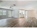 Open living space with wood-look floors, ceiling fan, and view into kitchen at 2628 Vista Palm Dr, Edgewater, FL 32141