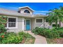 Inviting front entrance with blue door, lush landscaping, and a well-lit entryway at 2632 Turnbull Estates Dr, New Smyrna Beach, FL 32168