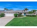 Charming single-story home with lush landscaping, blue door, and a two car garage at 2632 Turnbull Estates Dr, New Smyrna Beach, FL 32168