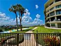 Scenic view of the condo, palm trees, a waterway, and a blue sky with fluffy clouds at 2700 N Peninsula Ave # 322, New Smyrna Beach, FL 32169