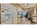 Open-concept kitchen with white cabinets, tile floors, and a breakfast bar overlooking the living area at 2700 N Peninsula Ave # 322, New Smyrna Beach, FL 32169