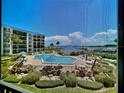 Overhead view of the condo community pool with seating, and the water way visible at 2700 N Peninsula Ave # 322, New Smyrna Beach, FL 32169