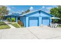 Charming blue home featuring a two-car garage and well-manicured landscaping at 3326 S Peninsula Dr, Port Orange, FL 32127