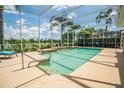 Sparkling screened-in pool with lush landscaping and serene lake views at 3577 Maribella Dr, New Smyrna Beach, FL 32168