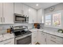 Well-lit kitchen with white cabinets, stainless steel appliances, and marble countertops at 4151 S Atlantic Ave # 3090, New Smyrna Beach, FL 32169