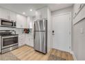 Updated kitchen features stainless steel appliances, white cabinets, and wood-look floors at 4151 S Atlantic Ave # 3090, New Smyrna Beach, FL 32169