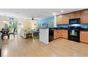 Open-concept kitchen with modern appliances, wood floors and a cozy living space at 511 Mount Olympus Blvd, New Smyrna Beach, FL 32168