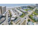Aerial view of condo complex situated by the beach with community pool, tennis courts, and private parking at 525 N Atlantic Ave # 39, New Smyrna Beach, FL 32169