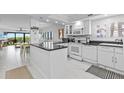 Bright kitchen with white cabinetry, black countertops and eat in dining room at 5301 S Atlantic Ave # 140, New Smyrna Beach, FL 32169