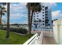 Exterior view of the community pool and condo building with palm trees at 5301 S Atlantic Ave # 140, New Smyrna Beach, FL 32169