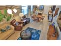 Open-concept living space with neutral tiling, comfortable seating, and adjacent dining area at 551 Armoyan Way, New Smyrna Beach, FL 32168