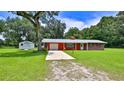 Exterior shot of a well-maintained home featuring a front lawn, driveway, and storage shed at 585 Corbin Park Rd, New Smyrna Beach, FL 32168