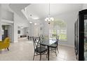 Dining room featuring a glass table, chandelier, and an arched window at 5935 Shady Creek Ln, Port Orange, FL 32128