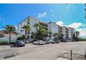 Spacious condo building exterior with ample parking, complemented by lush palm trees and greenery, offering a serene environment at 6727 Turtlemound Rd # 318, New Smyrna Beach, FL 32169