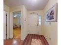 Inviting foyer with decorative front door, painting, and wood flooring, offering a warm welcome into the home at 686 Middlebury Loop, New Smyrna Beach, FL 32168