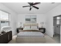 Bright bedroom featuring a ceiling fan and ensuite bathroom with glass shower at 7223 Sw 61St Pl, Ocala, FL 34474