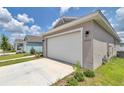 Side view of a well-kept two-car garage on a single-story home with a clean concrete driveway at 7223 Sw 61St Pl, Ocala, FL 34474