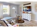 Cozy living room with couch, decorative accents, light wood floors, bright windows and neutral paint at 903 Conrad Dr, New Smyrna Beach, FL 32168
