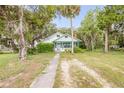 Inviting exterior with a long driveway, mature trees and well kept lawn at 102 N Brooks Cir, Oak Hill, FL 32759
