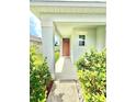 Inviting front porch featuring well-maintained landscaping and stylish front door at 103 Old Mill Pond Rd, Edgewater, FL 32141