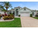 Charming home with arched windows, manicured lawn, and two car garage at 1221 Siesta Key Cir, Port Orange, FL 32128