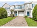 Inviting townhome with brick paver driveway, well-kept lawn, and a vibrant blue front door at 1453 River Rock Ct, Oviedo, FL 32765