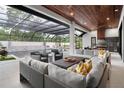 Comfortable outdoor living area featuring plush seating, a cozy fireplace, and a beautiful pool at 1616 Turnbull Crossings Dr, New Smyrna Beach, FL 32168
