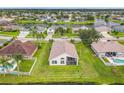 Aerial view of a house with a screened lanai, surrounded by a well-maintained lawn and scenic lake views at 1809 Forough Cir, Port Orange, FL 32128