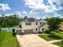 Aerial view of a beautiful home with solar panels, green lawn, and lush landscaping at 19 Abacus Ave, Ormond Beach, FL 32174
