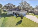 Well-maintained single-story home with a spacious yard, long driveway, and attached garage at 1929 Pioneer Trl, New Smyrna Beach, FL 32168