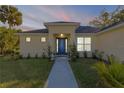 Charming home featuring a blue front door, well-maintained landscaping, and a welcoming walkway at 1929 Pioneer Trl, New Smyrna Beach, FL 32168