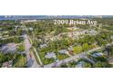An aerial view of a neighborhood showcasing a beautiful home surrounded by lush greenery and other houses at 2009 Brian Ave, South Daytona, FL 32119