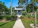 Beautiful two-story home featuring a well-manicured lawn, lush greenery, and a welcoming walkway at 206 S Riverside Dr, Edgewater, FL 32132