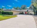 Spacious home with a large concrete driveway and well maintained landscaping leading to a vibrant red front door at 2338 Tuscarora Trl, Maitland, FL 32751