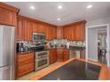Kitchen featuring stainless steel appliances, granite countertops, and beautiful mosaic backsplash at 2338 Tuscarora Trl, Maitland, FL 32751