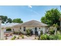 Charming single story home with landscaping, mature trees, and brick walkway, with a covered porch and table at 235 Randle Ave, Oak Hill, FL 32759