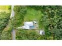 Expansive property with a sparkling pool, lush greenery, and distinct boundary lines, offering privacy and space at 2360 Mooneyham Dr, New Smyrna Beach, FL 32168